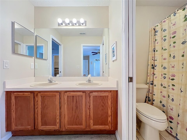 bathroom with curtained shower, vanity, and toilet