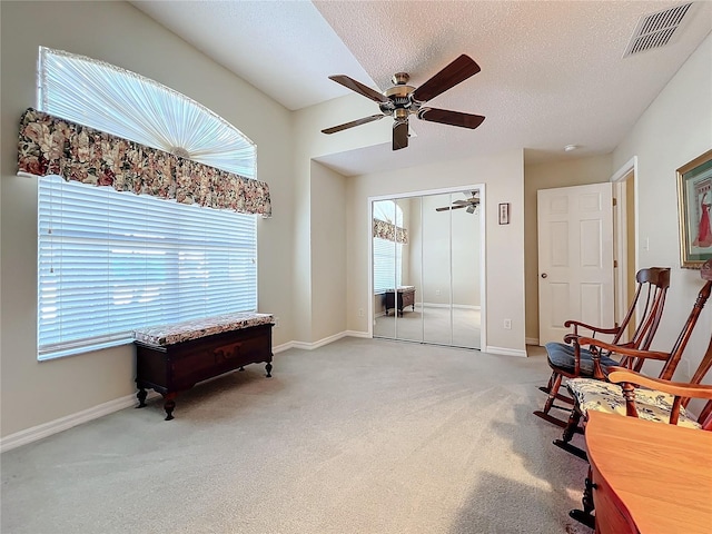 sitting room featuring carpet, a textured ceiling, and ceiling fan