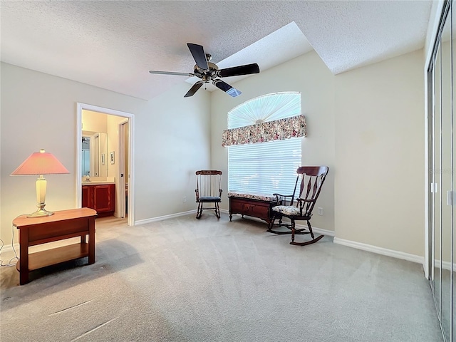 living area with a textured ceiling, light colored carpet, ceiling fan, and sink