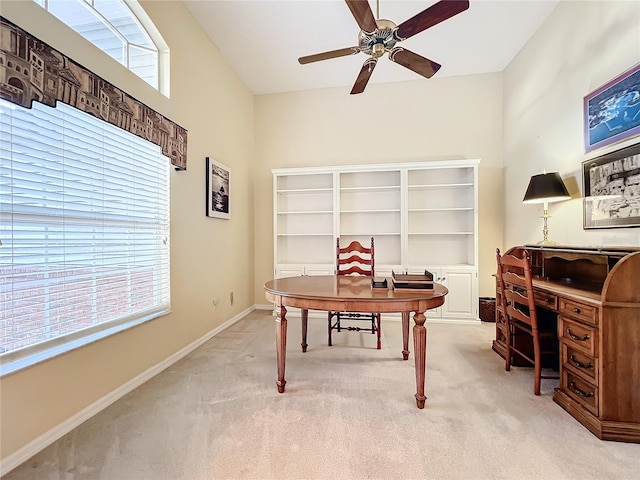 office space with a wealth of natural light, light colored carpet, and ceiling fan