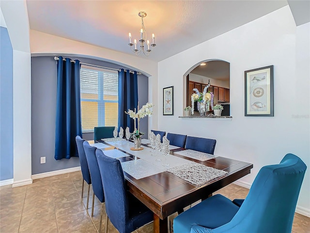 tiled dining room featuring a chandelier