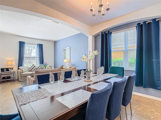 dining space with light tile patterned floors and a notable chandelier