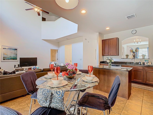 dining room featuring light tile patterned floors, ceiling fan with notable chandelier, and sink