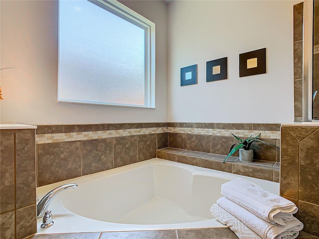 bathroom with plenty of natural light and tiled tub