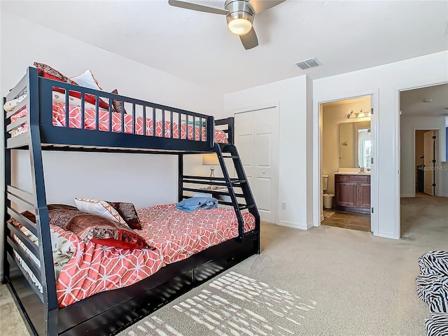 bedroom with ceiling fan, light carpet, connected bathroom, and a closet