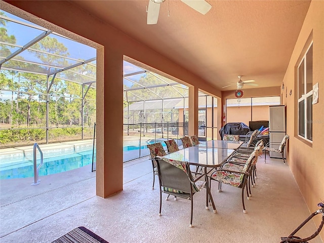 sunroom featuring ceiling fan and a swimming pool