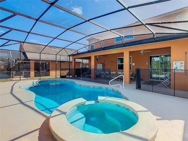 view of pool with glass enclosure, an in ground hot tub, ceiling fan, and a patio