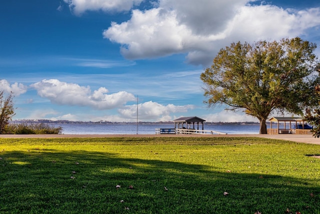 view of property's community featuring a lawn and a water view