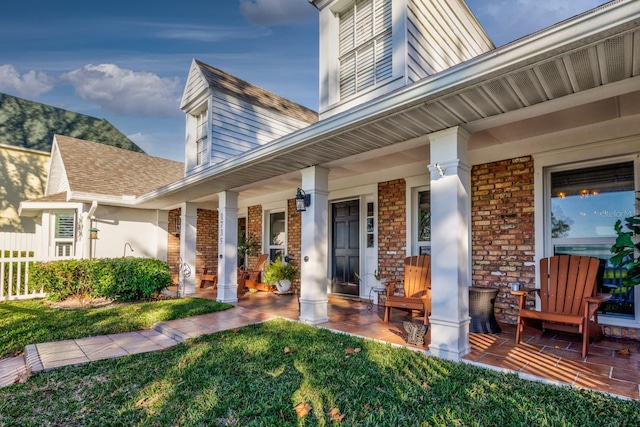 entrance to property featuring a porch and a yard