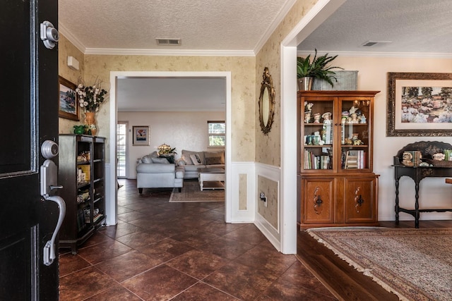 entryway with a textured ceiling and ornamental molding