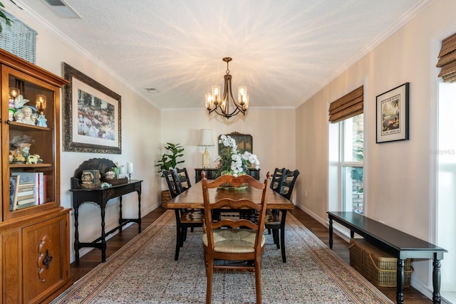 dining room featuring ornamental molding, a textured ceiling, dark hardwood / wood-style floors, and a notable chandelier