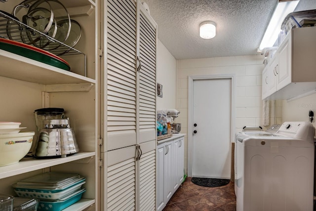 laundry area featuring cabinets, a textured ceiling, and washer and dryer