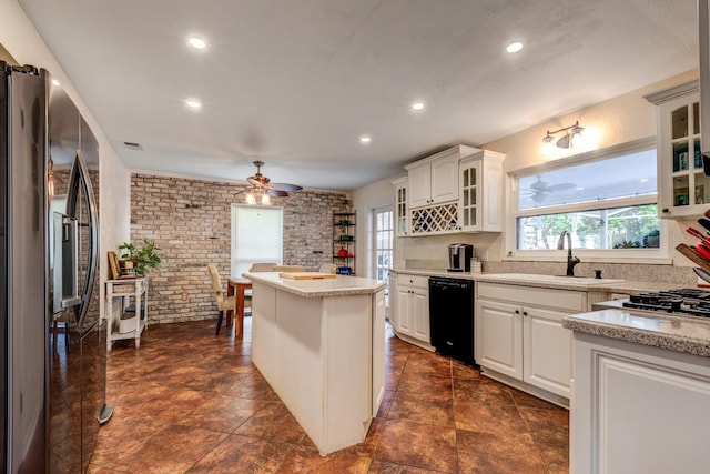 kitchen featuring dishwasher, stainless steel refrigerator with ice dispenser, white cabinets, and sink