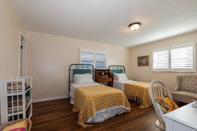 bedroom featuring dark hardwood / wood-style flooring and a textured ceiling