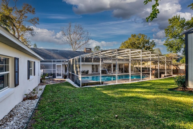 view of pool with a yard and glass enclosure