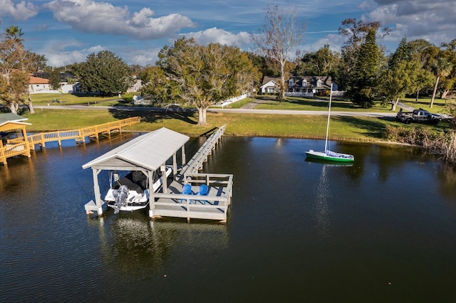 view of dock featuring a lawn and a water view