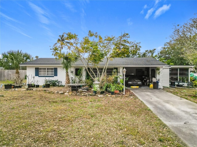 ranch-style home with a sunroom, a front lawn, and a carport