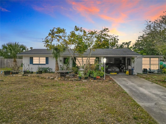 ranch-style home with a carport and a lawn