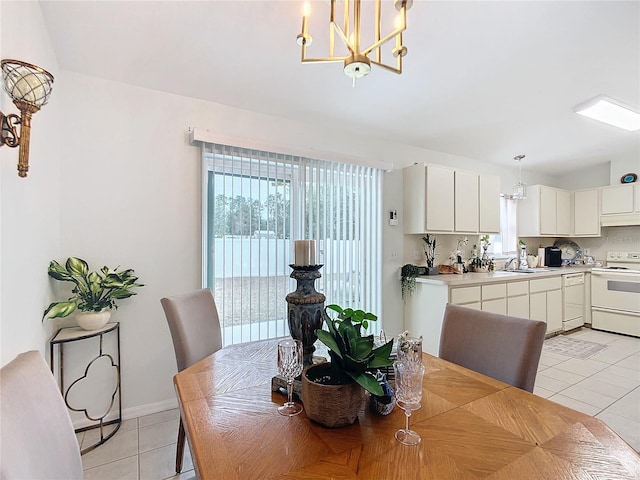 tiled dining room with an inviting chandelier and sink