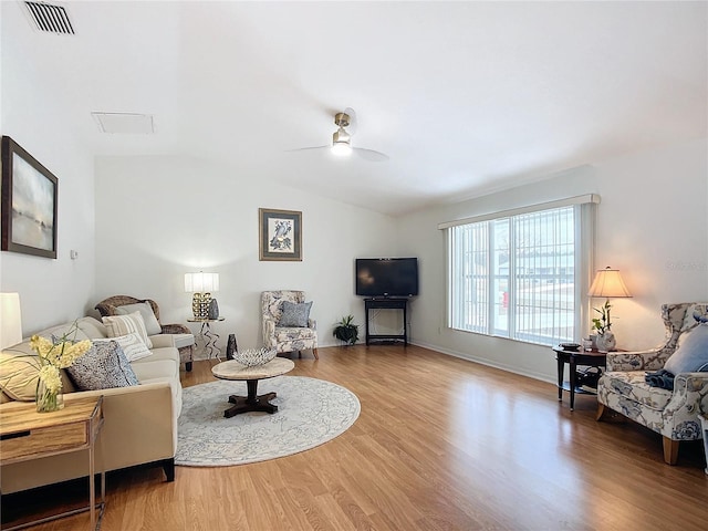 living room with ceiling fan, vaulted ceiling, and hardwood / wood-style flooring