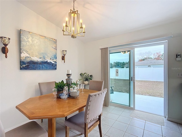 dining space featuring an inviting chandelier, light tile patterned floors, and lofted ceiling