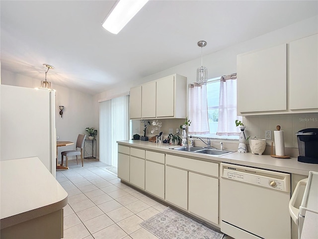 kitchen with white appliances, decorative light fixtures, tasteful backsplash, sink, and light tile patterned flooring