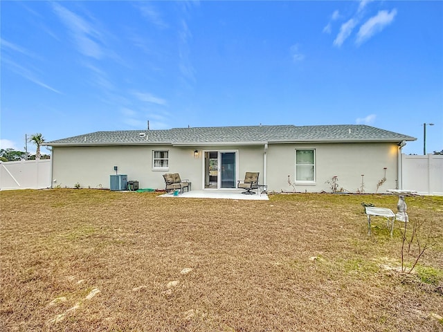 rear view of house with a patio area, a yard, and central AC