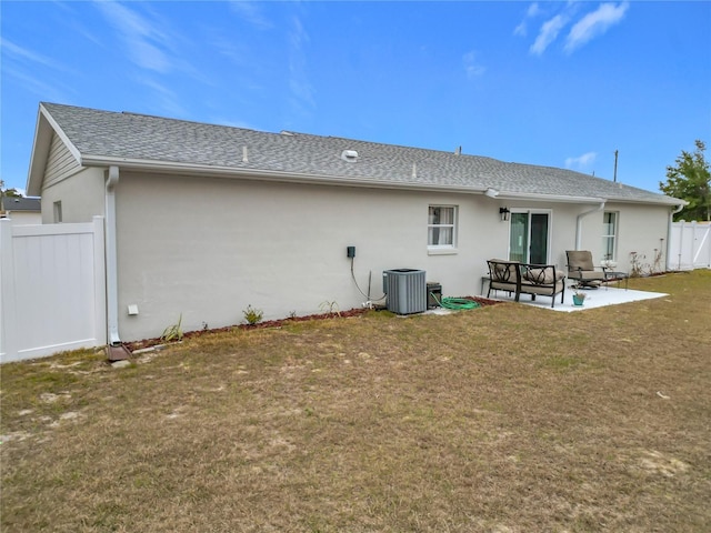 back of house with central AC unit, a patio, and a yard