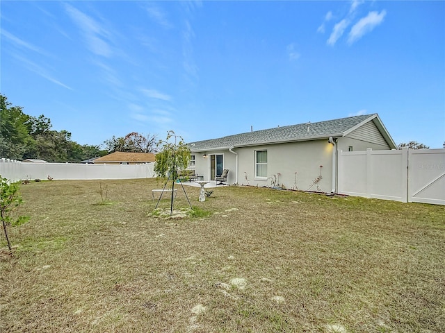 rear view of house featuring a patio area and a yard