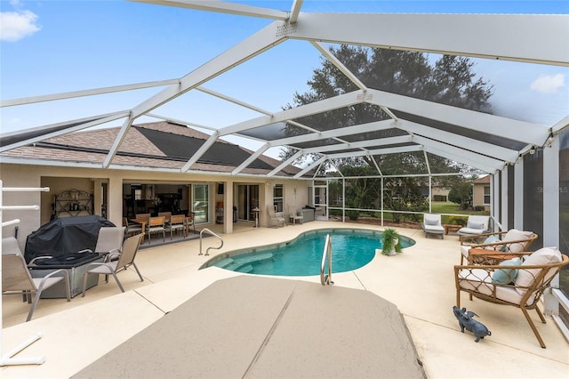 view of swimming pool with glass enclosure and a patio area