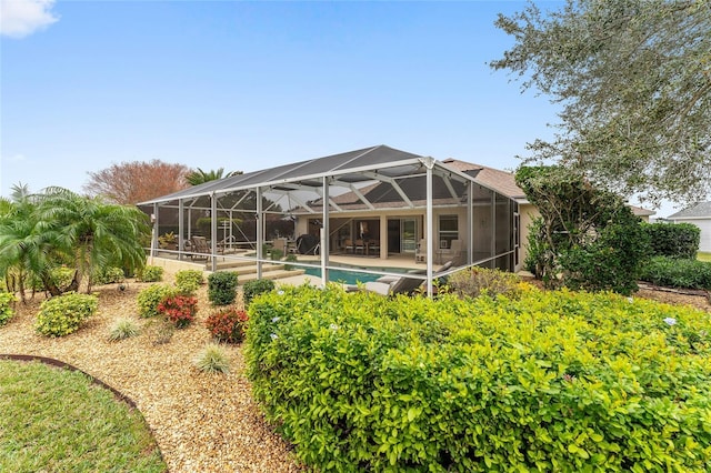 back of house with glass enclosure and a patio