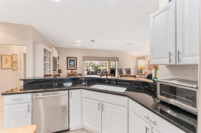 kitchen featuring kitchen peninsula, backsplash, dishwasher, white cabinets, and sink