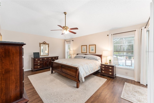 bedroom featuring ceiling fan, dark wood-type flooring, and a textured ceiling