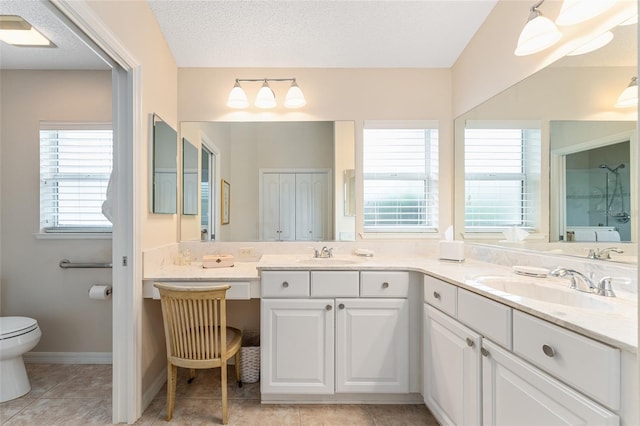 bathroom featuring toilet, vanity, tile patterned floors, and a textured ceiling