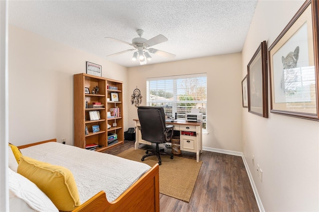 office space featuring dark wood-type flooring, ceiling fan, and a textured ceiling