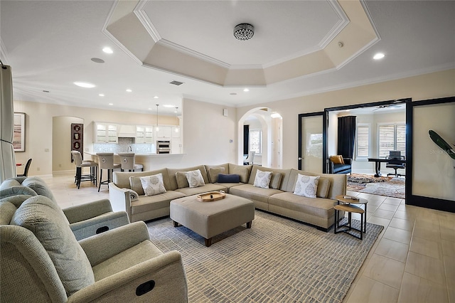 tiled living room with a raised ceiling and ornamental molding