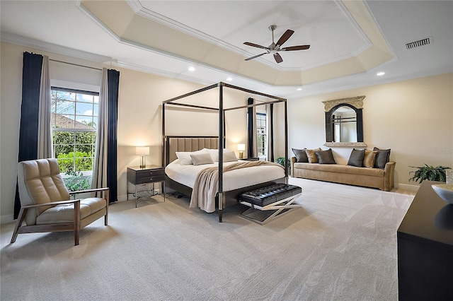 carpeted bedroom featuring a tray ceiling, ceiling fan, and ornamental molding