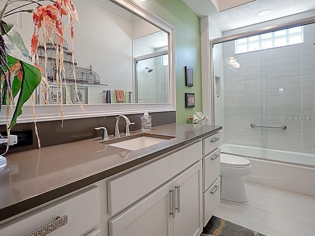 full bathroom with tile patterned floors, vanity, toilet, and shower / bath combination with glass door