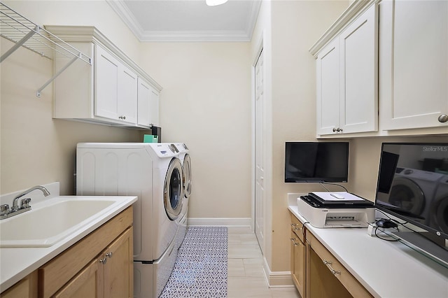 laundry area with cabinets, ornamental molding, sink, and washing machine and clothes dryer