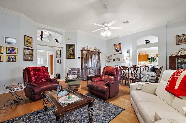 living room with light wood finished floors, visible vents, and crown molding