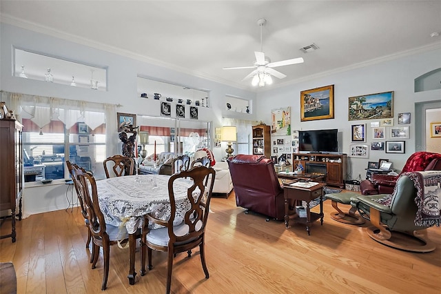 dining space with light wood finished floors, ceiling fan, ornamental molding, and visible vents