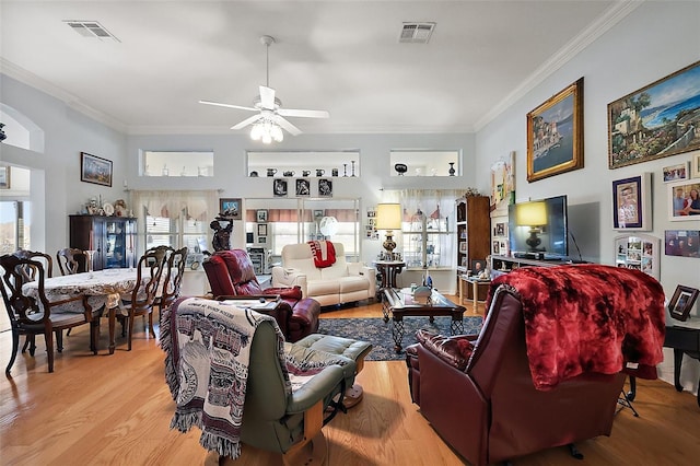 living room featuring ornamental molding, plenty of natural light, visible vents, and light wood-style floors