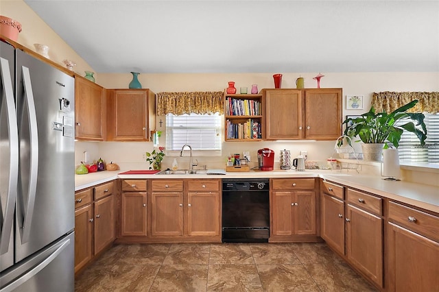 kitchen with freestanding refrigerator, light countertops, dishwasher, and a sink