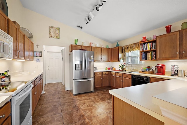 kitchen featuring brown cabinetry, white appliances, light countertops, and vaulted ceiling