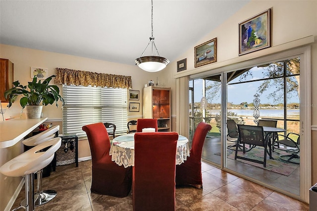 dining space featuring lofted ceiling and baseboards