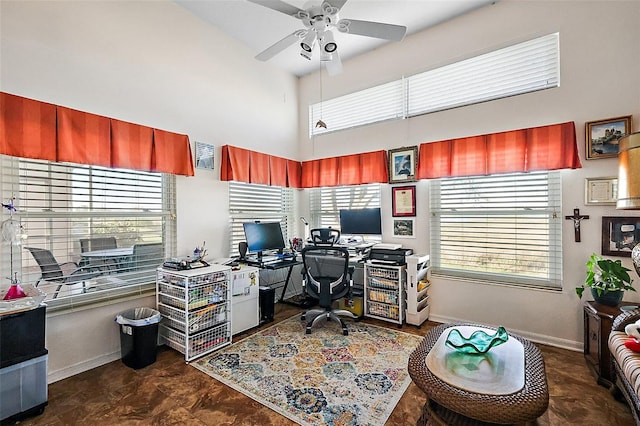 home office featuring a ceiling fan, a high ceiling, and baseboards