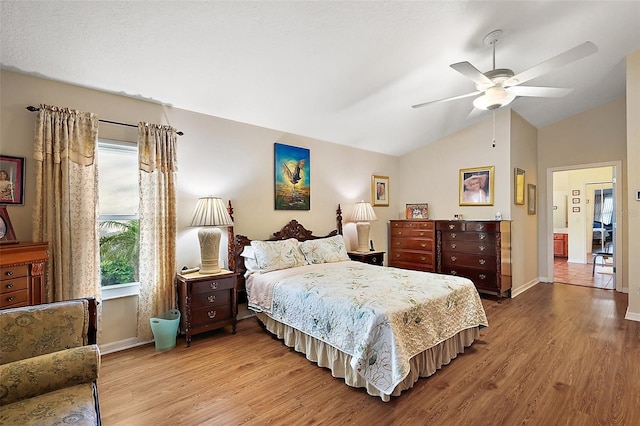 bedroom with vaulted ceiling, ceiling fan, wood finished floors, and baseboards