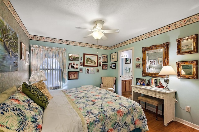 bedroom featuring ceiling fan, a textured ceiling, ensuite bath, wood finished floors, and baseboards