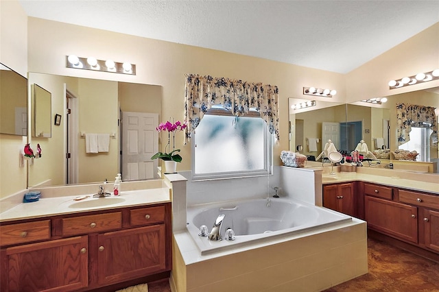 full bathroom with a garden tub, two vanities, and a sink