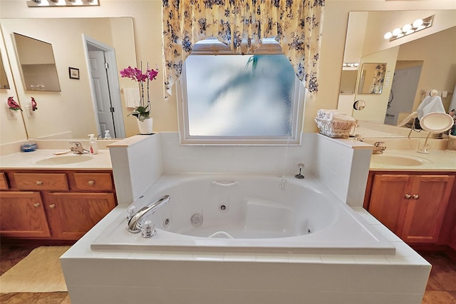 bathroom featuring two vanities, a sink, and a whirlpool tub